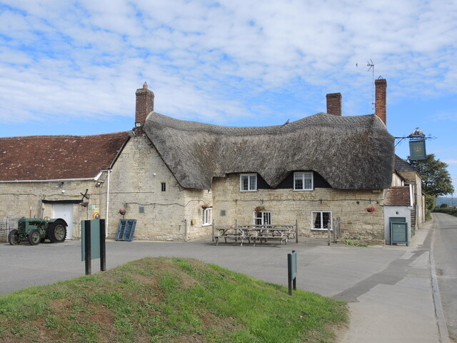 The Crown Inn, Marnhull — a thatched 16th-century stone pub behind a low wall